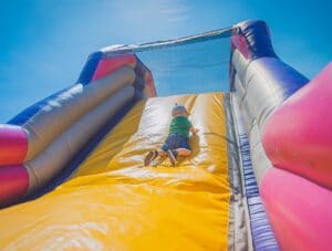 Child sliding down a bouncy castle