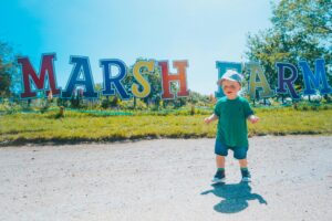Toddler in front of the Marsh Farm sign